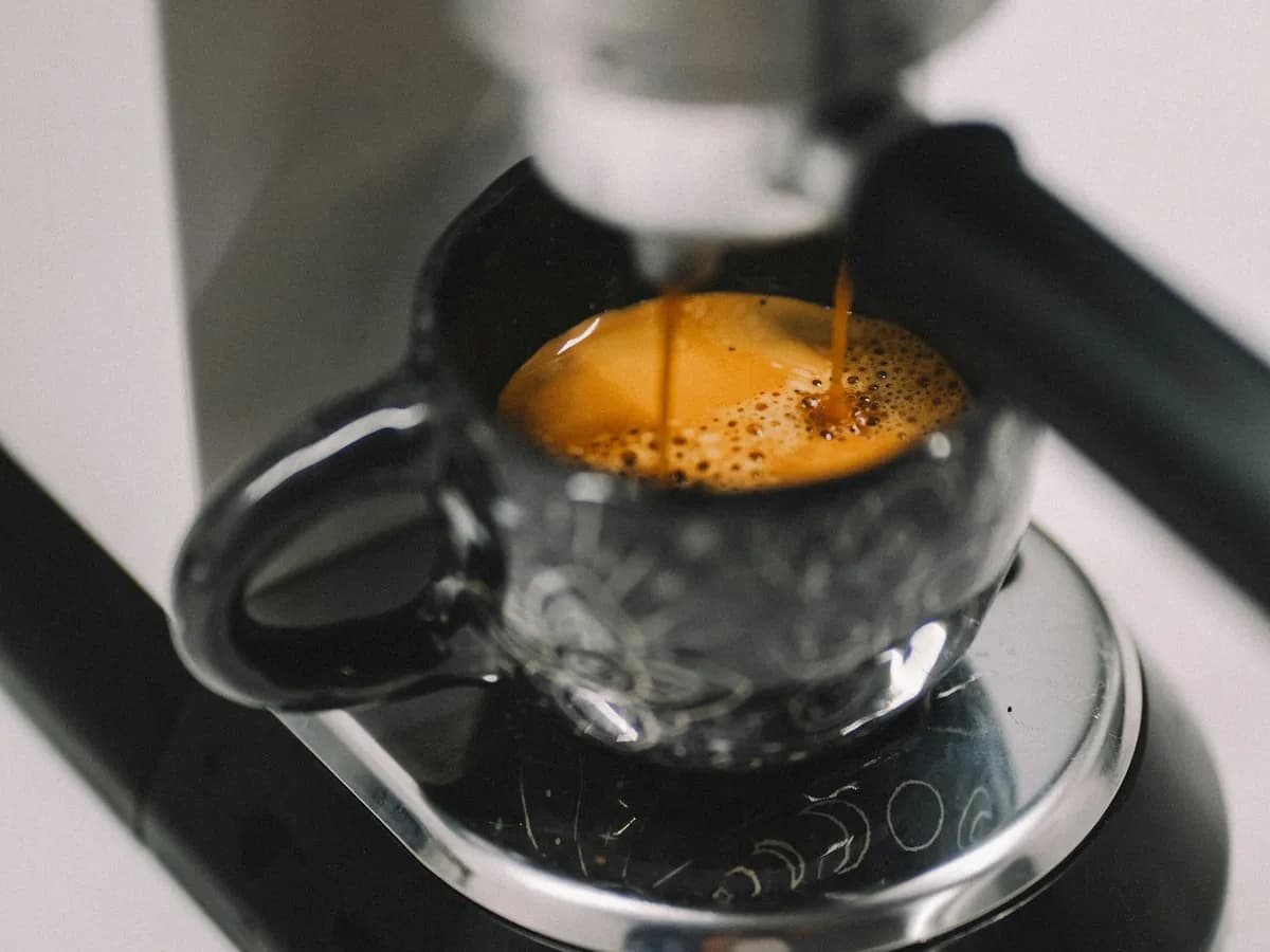 Espresso läuft in eine Glastasse