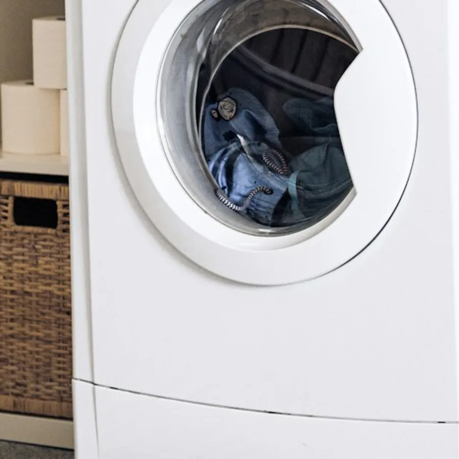 Geöffnete Waschmaschine mit Jeans in der Trommel